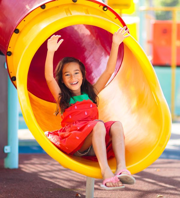 Image of girl sliding down colorful slide