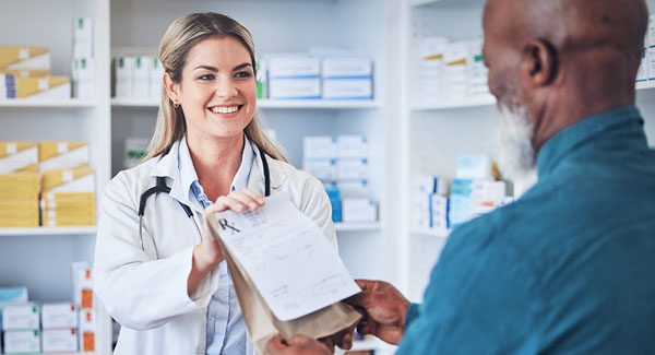 Pharmacist handing prescription to a customer